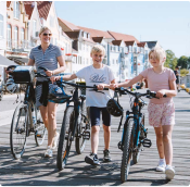 Familie der trækker deres cykler ved havnefronten