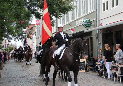 Person på en hest med dannebro til ringridning optog